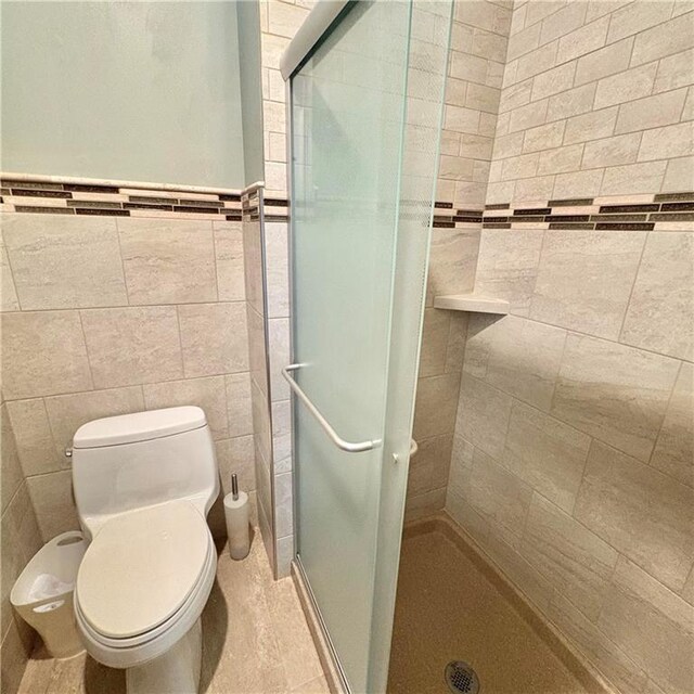 2405 W 123rd Ter, Leawood, KS 66209 - bathroom featuring toilet, a stall shower, and tile walls