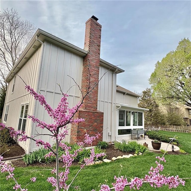 2405 W 123rd Ter, Leawood, KS 66209 - view of property exterior with a chimney, fence, a yard, board and batten siding, and a patio