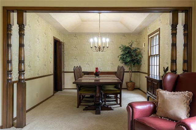 carpeted dining room featuring baseboards, an inviting chandelier, and a tray ceiling