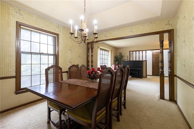 dining space featuring a chandelier, wallpapered walls, light colored carpet, and baseboards