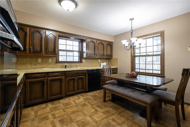 kitchen featuring dark brown cabinets, black dishwasher, light countertops, a chandelier, and a sink