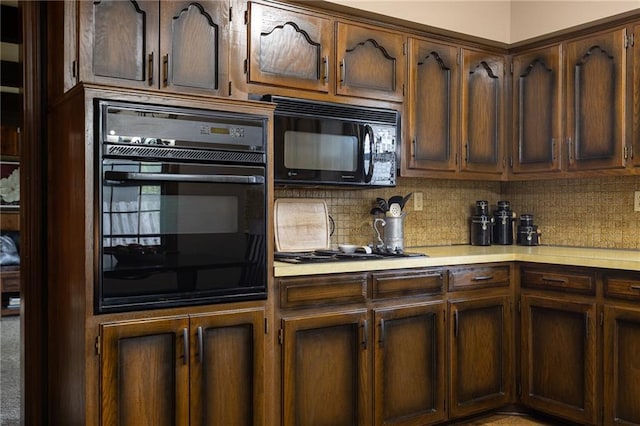 kitchen with light countertops, black appliances, and tasteful backsplash