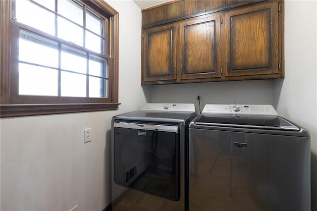 laundry room with baseboards, cabinet space, washing machine and dryer, and a healthy amount of sunlight