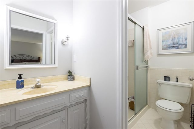 full bathroom with tile walls, a shower stall, vanity, tile patterned floors, and toilet