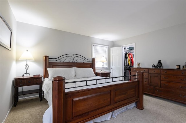 bedroom with a spacious closet and light carpet