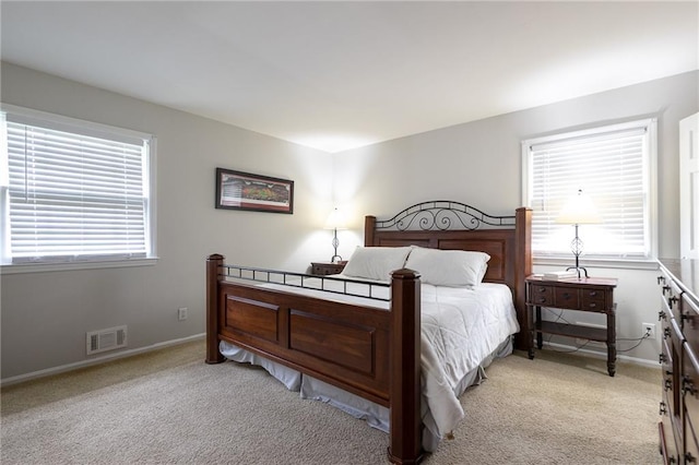 bedroom featuring light colored carpet, baseboards, and visible vents