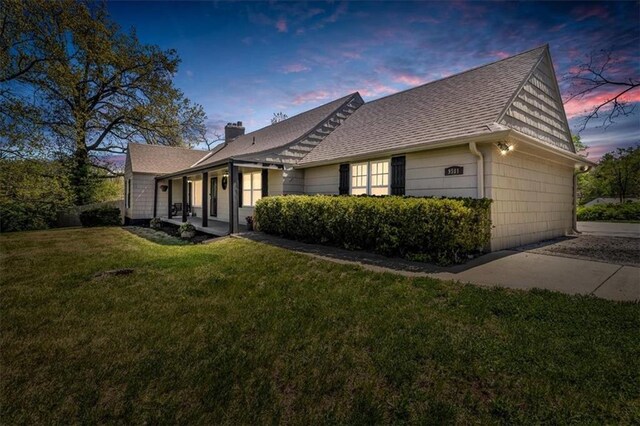 9501 Wornall Rd, Kansas City, MO 64114 - property exterior at dusk featuring a chimney, roof with shingles, and a yard
