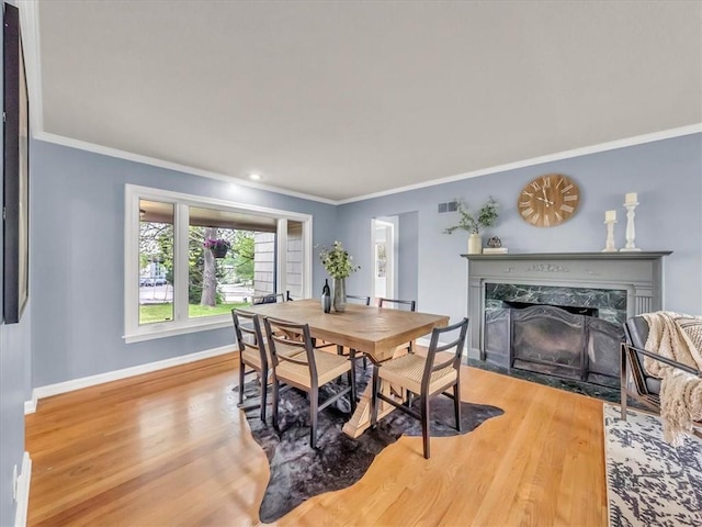 9501 Wornall Rd, Kansas City, MO 64114 - dining space with visible vents, baseboards, wood finished floors, ornamental molding, and a high end fireplace