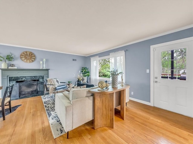 9501 Wornall Rd, Kansas City, MO 64114 - living room with visible vents, ornamental molding, a premium fireplace, baseboards, and light wood-style flooring