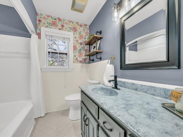 9501 Wornall Rd, Kansas City, MO 64114 - bathroom with wallpapered walls, tile patterned floors, toilet, vanity, and shower / tub combo with curtain