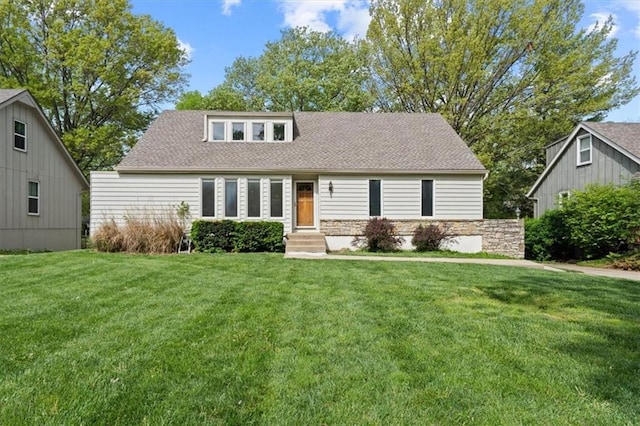 view of front facade with entry steps, a shingled roof, and a front yard