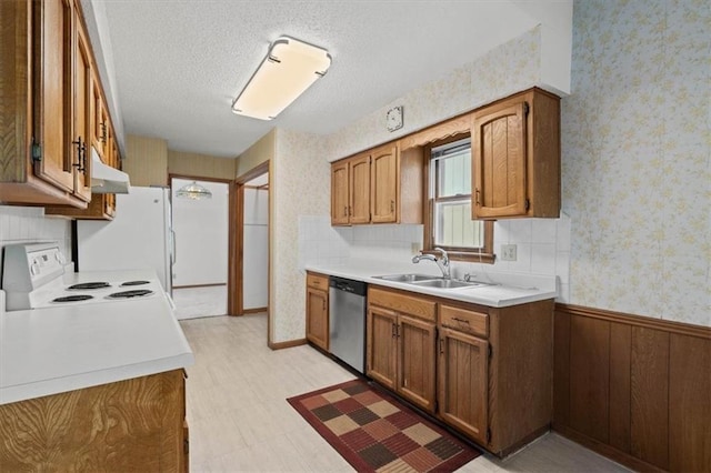 kitchen featuring a sink, white appliances, light countertops, wallpapered walls, and under cabinet range hood