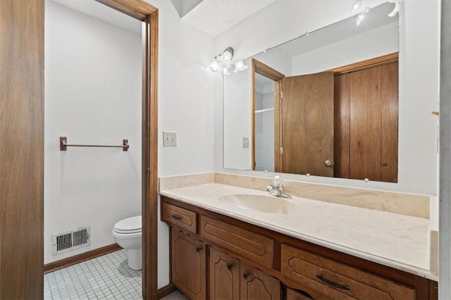 bathroom featuring vanity, tile patterned flooring, toilet, and visible vents