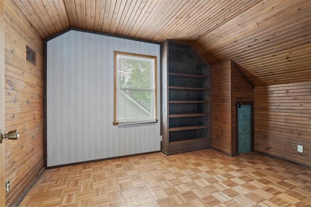 additional living space featuring baseboards, wood walls, wood ceiling, and lofted ceiling