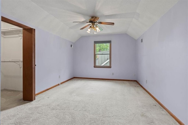 additional living space featuring carpet floors, ceiling fan, and vaulted ceiling