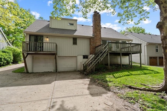 rear view of house featuring a shingled roof, a garage, stairway, a chimney, and concrete driveway