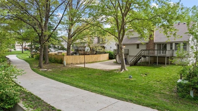 view of yard featuring stairway, a residential view, fence, and a wooden deck