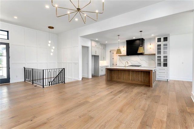 kitchen with light wood-type flooring, recessed lighting, white cabinetry, decorative backsplash, and light countertops