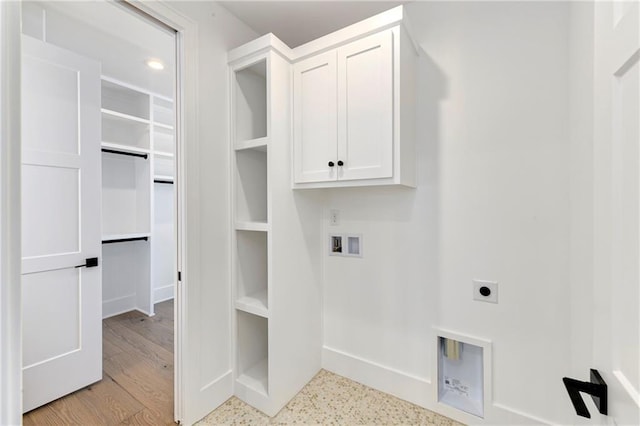 washroom with baseboards, electric dryer hookup, cabinet space, and washer hookup