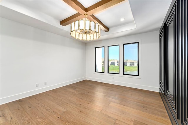 unfurnished room with baseboards, a notable chandelier, wood finished floors, and beamed ceiling