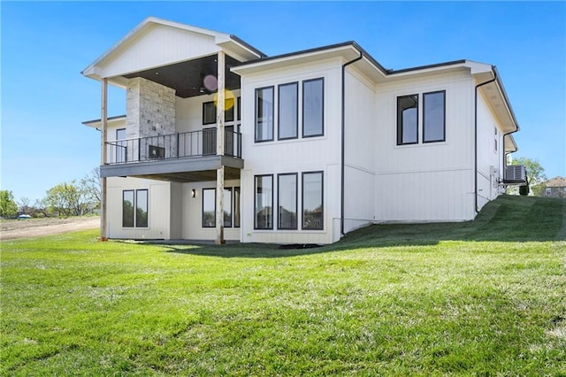back of house featuring a balcony, a yard, and cooling unit
