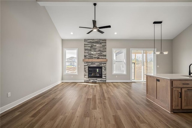25016 W 89th Ter, Lenexa, KS 66227 - unfurnished living room featuring a ceiling fan, wood finished floors, plenty of natural light, lofted ceiling, and recessed lighting