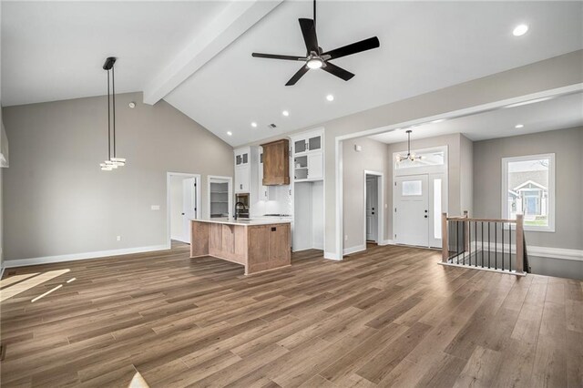 25016 W 89th Ter, Lenexa, KS 66227 - kitchen featuring open floor plan, beam ceiling, light countertops, wood finished floors, and glass insert cabinets