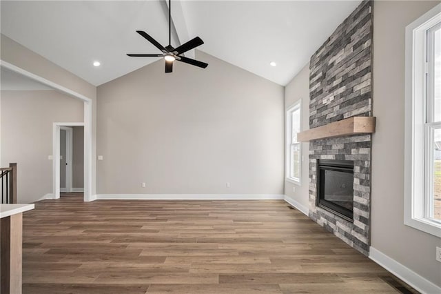 25016 W 89th Ter, Lenexa, KS 66227 - unfurnished living room with healthy amount of natural light, ceiling fan, high vaulted ceiling, a fireplace, and wood finished floors