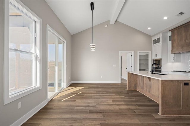 25016 W 89th Ter, Lenexa, KS 66227 - kitchen featuring beam ceiling, light countertops, stainless steel microwave, dark wood finished floors, and glass insert cabinets