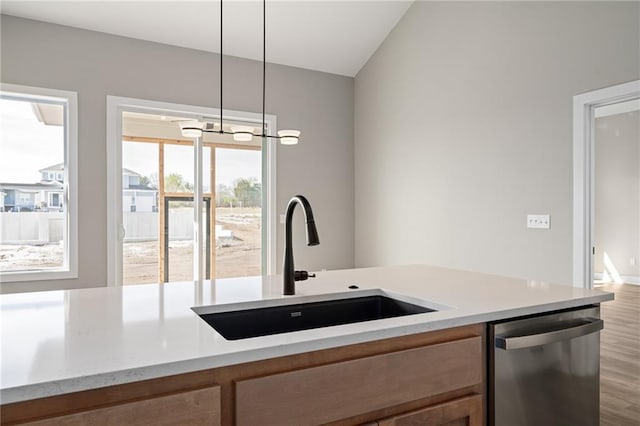 25016 W 89th Ter, Lenexa, KS 66227 - kitchen with stainless steel dishwasher, wood finished floors, hanging light fixtures, brown cabinets, and light stone countertops