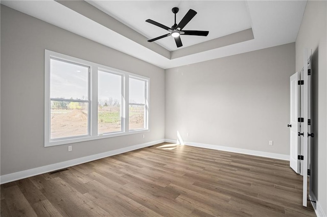 25016 W 89th Ter, Lenexa, KS 66227 - unfurnished room with wood finished floors, ceiling fan, and a raised ceiling