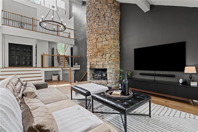 224 NW Locust St, Lees Summit, MO 64064 - living room with wood finished floors, high vaulted ceiling, a chandelier, beamed ceiling, and a stone fireplace