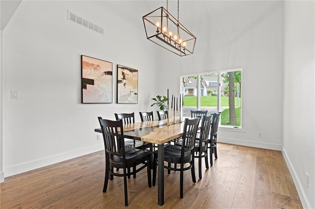 224 NW Locust St, Lees Summit, MO 64064 - dining room featuring a towering ceiling, wood finished floors, and a chandelier