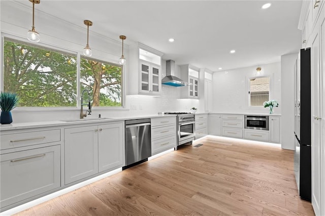 224 NW Locust St, Lees Summit, MO 64064 - kitchen featuring stainless steel appliances, wall chimney range hood, white cabinetry, backsplash, and pendant lighting