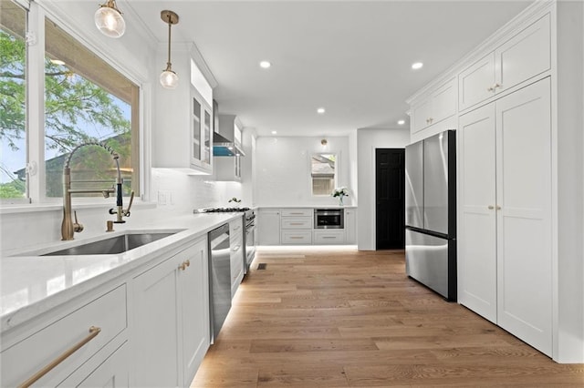224 NW Locust St, Lees Summit, MO 64064 - kitchen featuring appliances with stainless steel finishes, recessed lighting, white cabinetry, light wood-type flooring, and light countertops