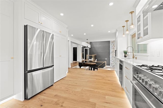 224 NW Locust St, Lees Summit, MO 64064 - kitchen featuring stainless steel appliances, extractor fan, white cabinets, glass insert cabinets, and recessed lighting