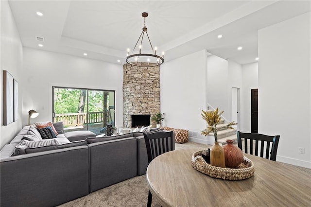 224 NW Locust St, Lees Summit, MO 64064 - living area with recessed lighting, a towering ceiling, a chandelier, a stone fireplace, and a raised ceiling