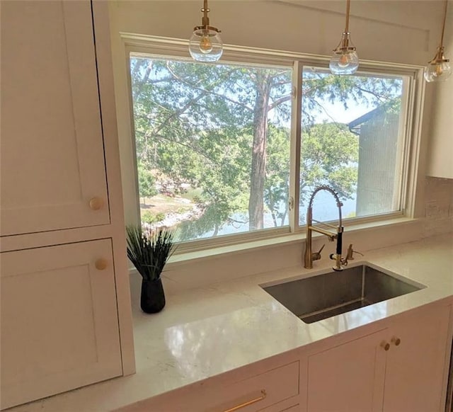 224 NW Locust St, Lees Summit, MO 64064 - kitchen with white cabinetry, hanging light fixtures, and light stone countertops
