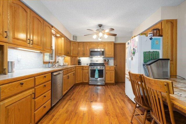 108 Sunrise Ct, Ozawkie, KS 66070 - kitchen featuring tasteful backsplash, light wood-style floors, ceiling fan, stainless steel appliances, and light countertops