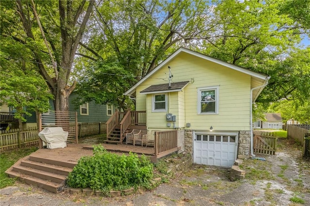 7235 Main St, Kansas City, MO 64114 - back of property with a wooden deck, an attached garage, and driveway