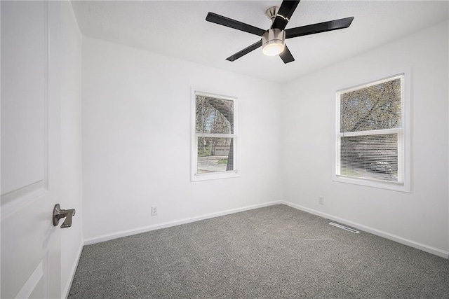 empty room featuring visible vents, ceiling fan, carpet flooring, and baseboards