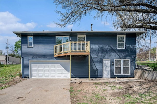 back of house featuring driveway, a balcony, and a garage