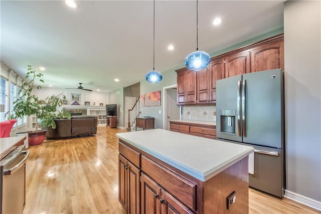 kitchen with decorative backsplash, a kitchen island, light countertops, light wood finished floors, and stainless steel appliances