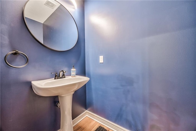 bathroom with baseboards, wood finished floors, and visible vents