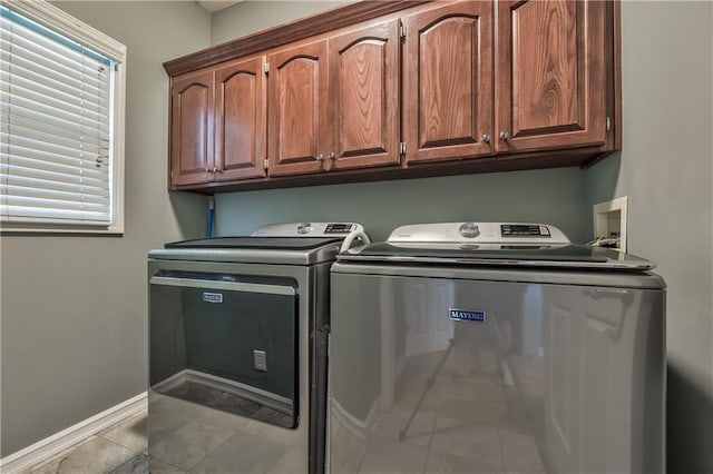 washroom with independent washer and dryer, baseboards, tile patterned flooring, and cabinet space