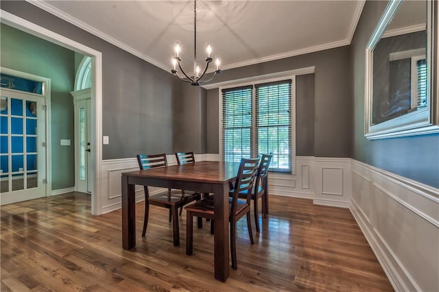 dining area featuring a chandelier, wainscoting, ornamental molding, and dark wood-type flooring