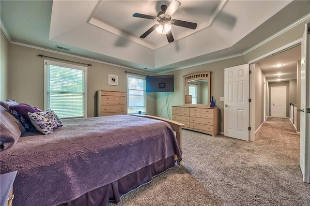 bedroom with ceiling fan, visible vents, crown molding, carpet floors, and a tray ceiling