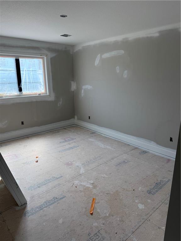 spare room with baseboards