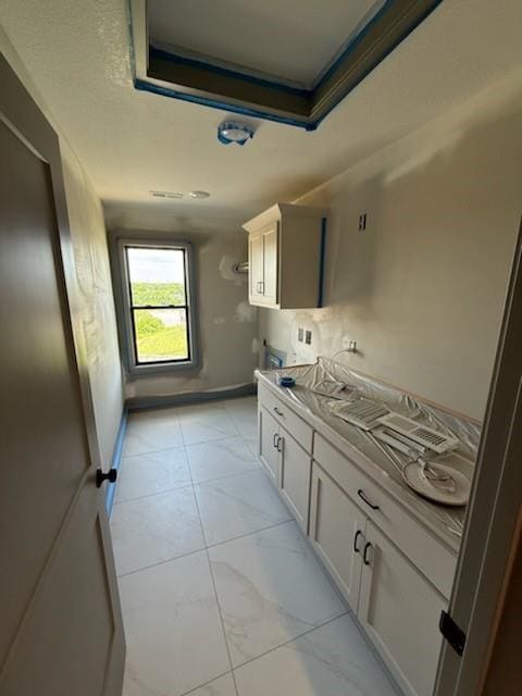 7080 NW Forest Lakes Dr, Parkville, MO 64152 - kitchen with a raised ceiling and light marble finish flooring