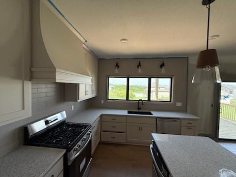 7080 NW Forest Lakes Dr, Parkville, MO 64152 - kitchen featuring appliances with stainless steel finishes, a sink, tasteful backsplash, and pendant lighting